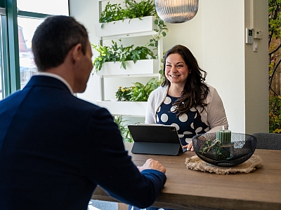 Beratungsgespräch zwischen Mitarbeiterin und Kunden in modernem, begrünten Büro der LBS NordOst